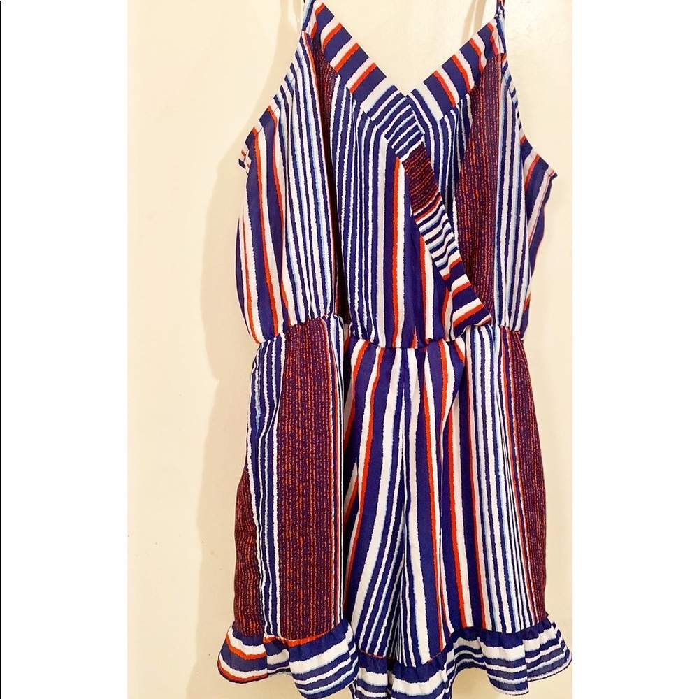 Multi-color romper w/ ruffle short bottoms & open back detail. Size: Small